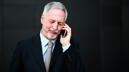 Senior manager on the phone looking happy