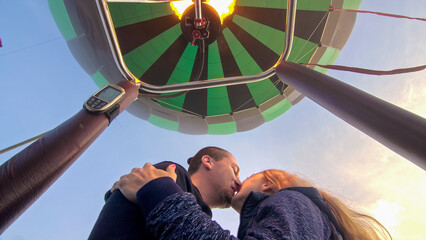 Adventure love couple on hot air balloon watermelon. Man and woman kiss hug love each other. Burner...