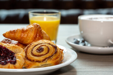 Continental breakfast of assorted pastries including croissant, Danish and cinnamon swirl served with coffee and orange juice