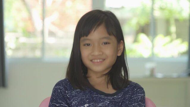 Portrait of happy smiling young Asian student girl studying from home and talking to friends in webcam group video call conference online in quarantine in corona virus pandemic. People lifestyle