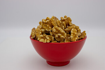 Peeled walnuts in red plate