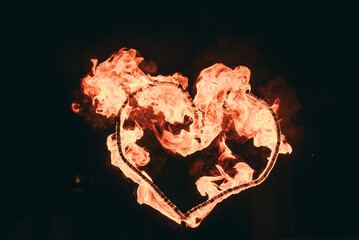 A burning, fiery heart on a black background. A figure in the form of a heart with fire