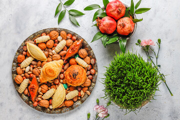 Traditional Azerbaijan spring holiday Nowruz tray with semeni - wheat grass, pakhlava, shekerbura,badambura,mutaki,gogal,flowers,dry fruits,spring flowers.