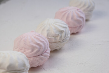 
Marshmallow without packaging close-up on a white background. side view. Zephyr pink and white. Protein sweetness. Air dessert.