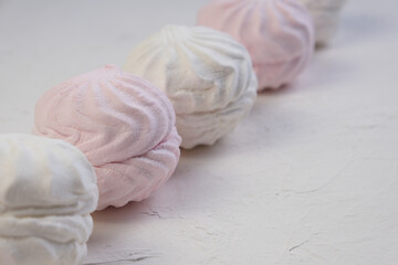 
Marshmallow without packaging close-up on a white background. side view. Zephyr pink and white. Protein sweetness. Air dessert.