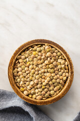 Uncooked brown lentils. Raw legume in bowl.