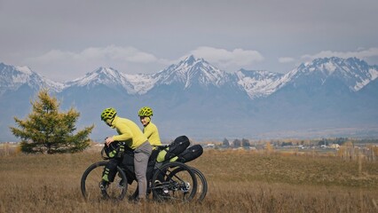 The man and woman travel on mixed terrain cycle touring with bikepacking. The love couple journey...