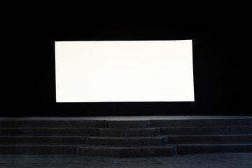 White mock-up screen on dark wall at cinema theater stage