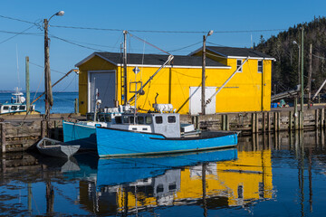Obraz premium Lobster Fishing Cove with boats on a bright summer day with Blue Sky and Yellow Building