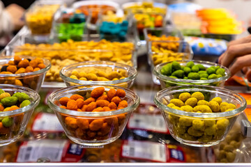 Nuts in spices, turmeric, paprika, pepper, salt and others are in the shop window