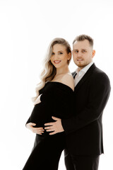 portrait of a couple, pregnant woman with her husband dressed in black on a white background.