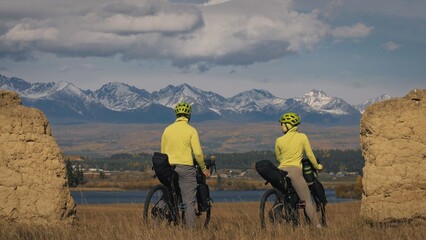 The man and woman travel on mixed terrain cycle bike touring with bikepacking. The two people...