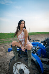 Fototapeta na wymiar Girl with long black hair in the countryside. Ipadrome with horses. Rural landscapes, wild west.