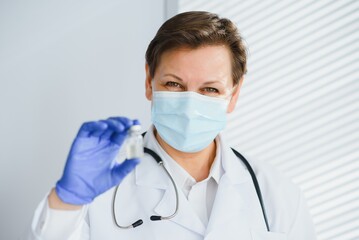 Closeup hand of woman doctor or scientist in doctor's uniform wearing face mask protective in lab...
