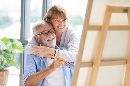 senior couple looking to painting on a canvas in free time - Powered by Adobe