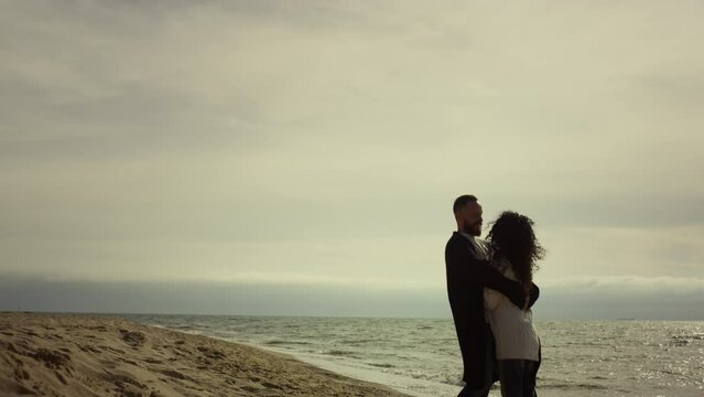 Beautiful couple embracing beach at nature. Boyfriend girlfriend hugging by sea.