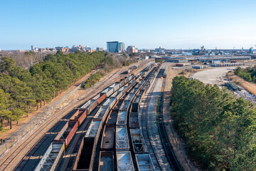 Aerial view of coal cars on train tracks looking at towards the city