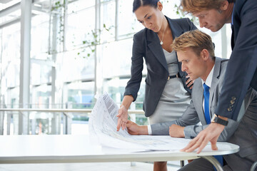 Our client requested some changes to the plans. Shot of three design professionals looking over...