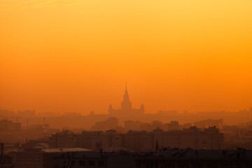Silhouette of Moscow State University building against orange sunset sky. Cityscape. Copy space.