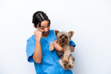 Young veterinarian woman with dog isolated on white background celebrating a victory