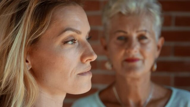 Senior mother looking at her adult daughter indoors at home. Selective focus.