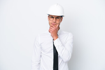 Young architect caucasian man with helmet and holding blueprints isolated on white background thinking