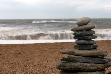 Fototapeta na wymiar Zen rocks against a backdrop of turbulent seas on an overcast day