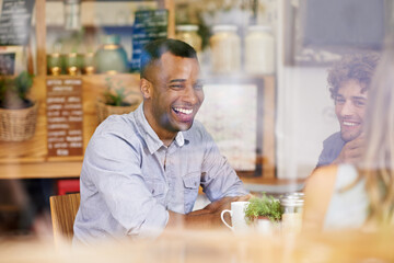 Catching up with his mates. Shot of a group of friends hanging out in a coffee shop.