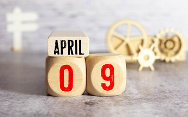 Cube shape calendar for April 09 on wooden surface with empty space for text.