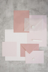 Top view of composition of colorful sheets of paper, white and pink envelopes sealed with wax,...