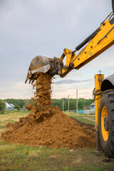 Close up of an excavator digging a deep trench. An excavator digs a trench in the countryside to...