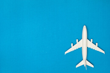 Fototapeta premium Airplane model. White plane on blue background. Travel vacation concept. Summer background. Flat lay, top view, copy space.