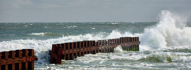 Heavy surf and waves pounds the rusting iron sea wall where the Cape Hatteras lighthouse was...