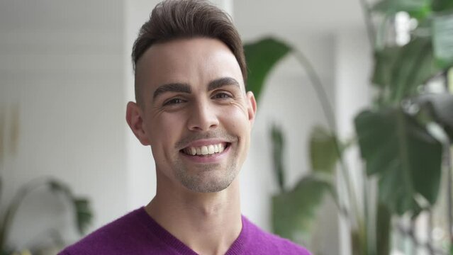 Portrait of Handsome Hispanic Gay male standing at home looking happy to camera with smile 