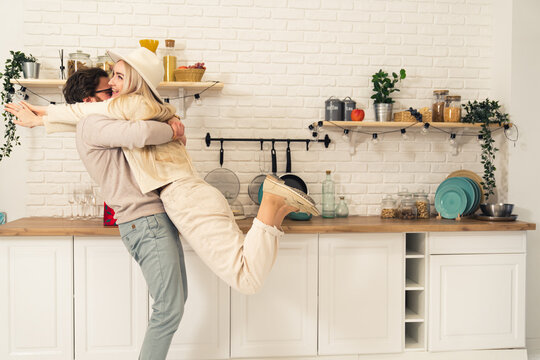 extremely happy caucasian long-haired blonde girlfriend is held up by her partner while celebrating Valentine's Day or Woman's Day. High quality photo