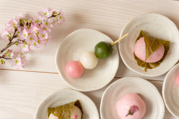 Japanese sweets to eat in spring. Three-color dumplings, sakura mochi, buns.  春に食べる日本の和菓子。3色団子、桜餅、饅頭