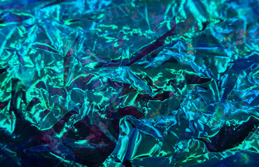 colorful grunge background. Rough texture. Neon light red green blue shiny wrinkled rock dark abstract art.