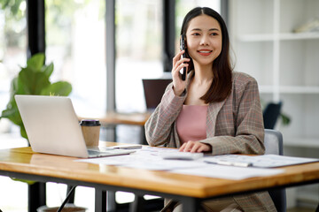 Fototapeta na wymiar Asian young businesswoman working in the office with laptop computer, doing planning analyzing the financial report, business plan investment, finance analysis concept