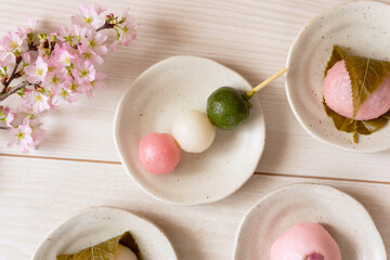 Obraz na płótnie Canvas Japanese sweets to eat in spring. Three-color dumplings, sakura mochi, buns. 春に食べる日本の和菓子。3色団子、桜餅、饅頭