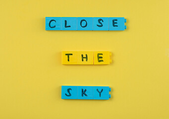 An inscription with a request to close the sky over Ukraine on a yellow background. The concept of a request to NATO to close the sky.