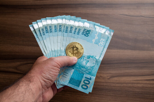 brazil currency bank note hundred reais with bitcoin coin