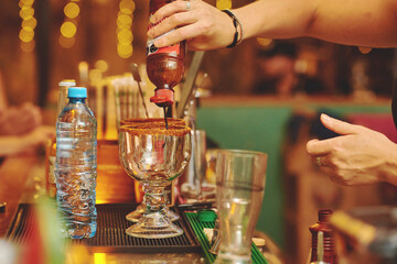 Female barman preparing drinks. cocktail bar Drinks at the bar. Fresh and cold drinks in a bar. Watermelon drink, jamiaca drink, margarita, micheladas.