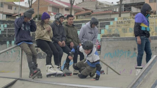 group of rollerbladers watch two kids doing tricks