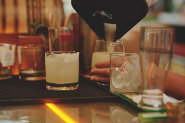 Female barman preparing drinks. cocktail bar Drinks at the bar. Fresh and cold drinks in a bar. Watermelon drink, jamiaca drink, margarita, micheladas.