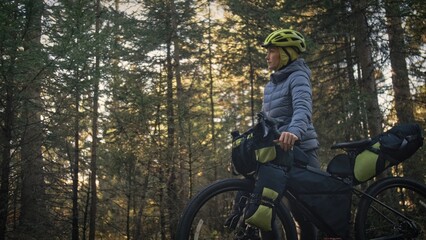 The woman travel on mixed terrain cycle touring with bike bikepacking outdoor. The traveler journey...