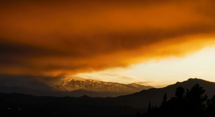 Rosso tramonto sulle cime dei monti tra luce e tenebre