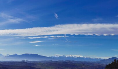 Montagne innevate e vallate nel cielo azzurro in una tersa giornata di sole invernale