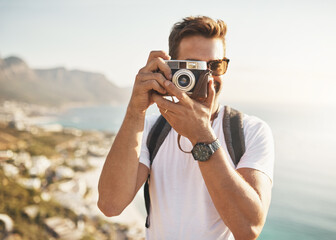 Say cheese. Cropped portrait of a handsome young man taking photographs while hiking in the...