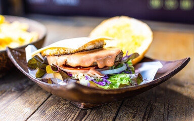 Closeup shot of delicious tasty yummy homemade breakfast juicy patty grilled beef cheeseburger with sliced vegetable lettuce cabbage tomato onion and melting spicy sauce in wooden bowl on wood table