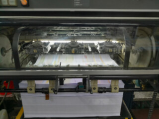 Blurred image of a modern four colour printing machine running in high speed. Shot at Kolkata, West Bengal, India.